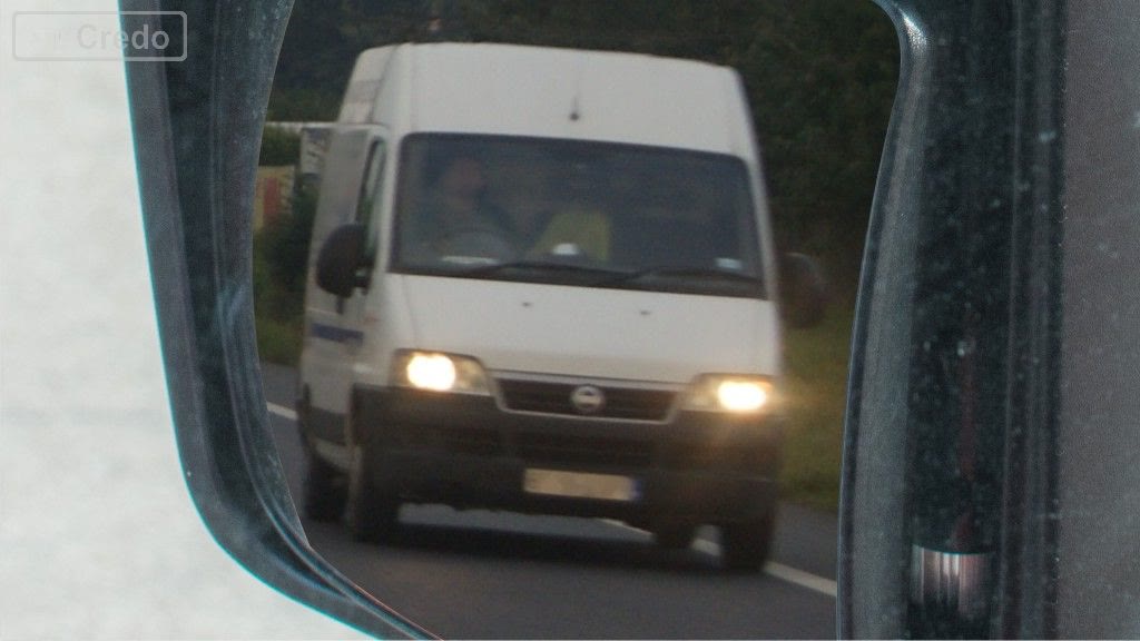 Question illustration: You are travelling on a road at the maximum permitted speed, and in spite of that you see a vehicle approaching from behind and blinking the lights. What do you do in this situation?