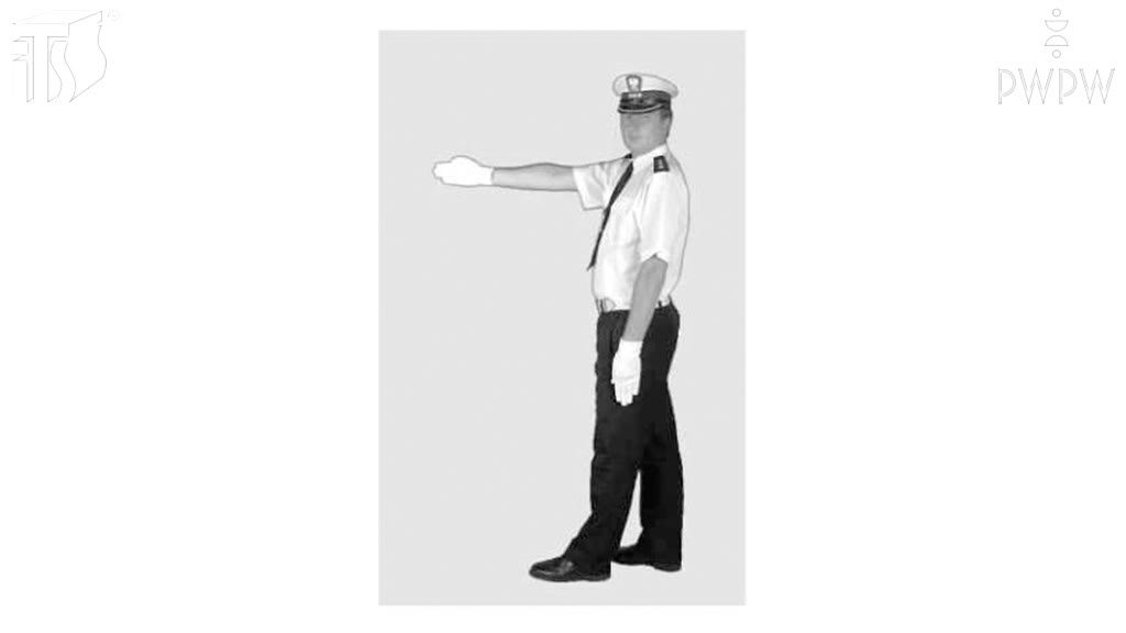 Ilustracja do pytania: Czy widząc taką postawę policjanta kierującego ruchem możesz przejechać na wprost przez skrzyżowanie?