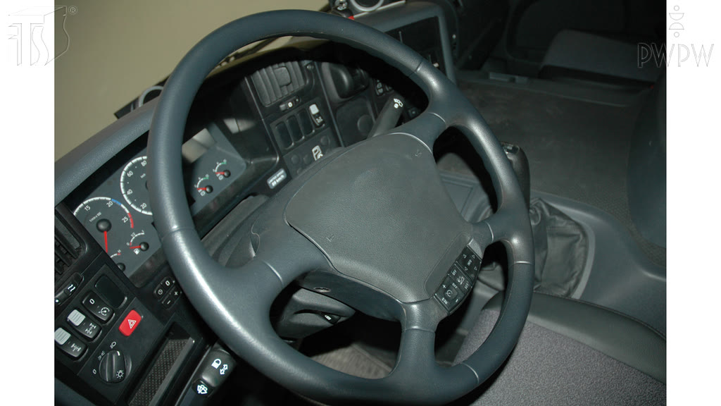 Question illustration: What is the correct position of the hands on a steering wheel while driving a truck on a motorway?